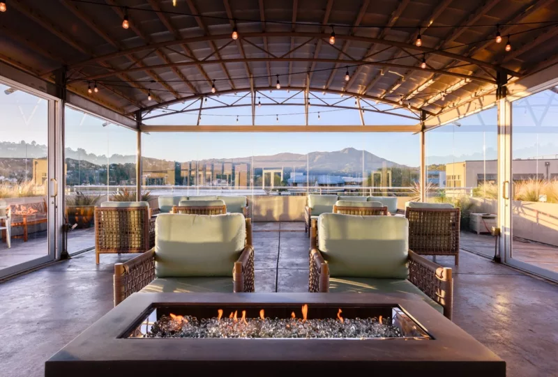 inside the glassed-in atrium with comfortable chairs and fire features and full view of Mt Tam in the background