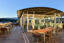 Glassed-in rooftop atrium at sunrise, with tables and chairs on open air patio surrounding the atrium8-7132.jpg